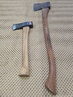 Photo of both axes showing overall condition and size difference, wooden handles and metal heads.