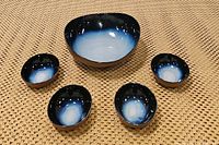 The full set with one large bowl in the center and four smaller matching bowls arranged around it, showing the gradient blue ombre color effect and ceramic material.