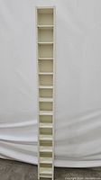 Front view of tall, slim white wooden CD rack with multiple compartments.