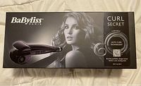 Box of BaByliss Curl Secret automatic hair curler showing model image and key features