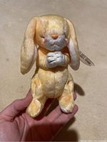 Front view of the yellow Grace Beanie Baby bunny showing praying position and face details
