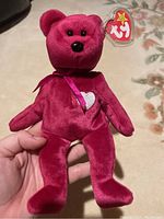 Front view of red Ty Beanie Baby Valentina bear showing face, sewn heart on chest, pink ribbon and original tag
