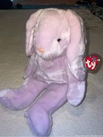 Photo of lavender purple Floppity Beanie Buddy plush with tag visible on ear.