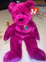 Front view of the pink Ty Beanie Buddy Millennium bear showing embroidered chest patch and heart-shaped Ty tag with ribbon.