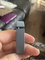 Front view of the grey Fitbit fitness tracker wristband showing the display area with an illuminated light.