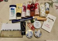 Photo of assorted lotions, sprays, creams, and a branded pouch on carpet.