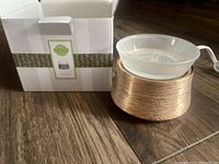 Photo showing rose gold electric Scentsy warmer with frosted glass dish beside its original packaging box.
