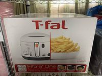 Photo of factory sealed T-fal Filtra One deep fryer box showing the product image and promotional details on the packaging.