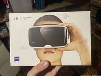 Front of the VR ONE PLUS box showing the headset on a person's face and ZEISS logo.