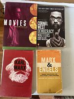 Photo showing four paperback books on a flat surface: 'Movies and the Meaning of Life', 'Democracy Matters' by Cornel West, 'Karl Marx' by Gajo Berlin, and 'Marx & Engels Basic Writings on Politics & Philosophy'.