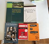 Nine psychology, philosophy and intellectual themed books arranged on white surface.