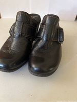 Front view of dark brown leather B.O.C. clog shoes showing textured leather, top stitching, and strap with buckle detail