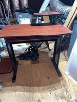 Full front view of brown particle board desk with metal legs and side housing shelf.
