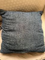 Solid blue textured couch pillow with visible weave and color variations.