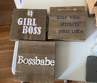 Three wooden decor plaques with inspirational quotes displayed on a white surface.