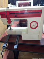 Front and side views of Brother sewing machine showing stitch selection dial and exposed bottom rail area