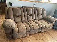 Front view of the brown sofa recliner showing the plush seating and armrests.