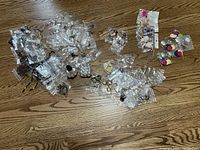 Several bags containing assorted costume jewelry on wooden floor