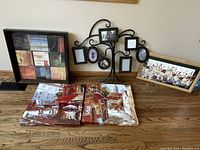 Overview of all six wall pieces including decorative tree photo frame and framed paintings, showing arrangement on wooden floor against cream wall.