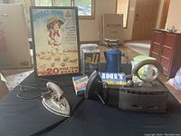 Antique irons displayed on table with vintage laundry detergent boxes and framed Borax sign in background.