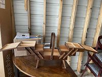 Photo of vintage wooden sewing box fully open, showing multiple fold-out trays for organizing sewing supplies.