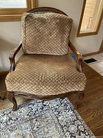 Front view of vintage wooden chair with lattice patterned upholstery and removable cushion