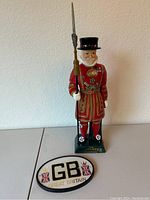 Ceramic Beefeater Yeoman decanter and GB Great Britain ceramic sign on table.