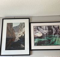 Two framed photographs hanging on a wall: Santa Elena on the left and Precipice Lake on the right.