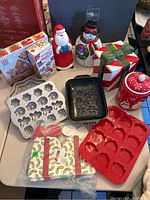 Overview of the entire lot showing all molds, ceramic containers, gingerbread kit, and paper boxes.