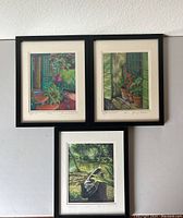 Three framed prints displayed on wall showing garden and nature scenes.