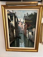 Frontal view of painting in gold-tone frame with attached picture light