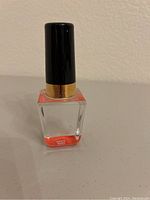 Front view of Kosta Boda glass sculpture showing clear glass with red hand-painted accents and black top with gold band.