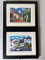 Both framed art prints stacked vertically hanging on wall showing Mermaid Street scenes by MJ Preston