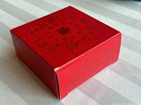 Red decorative outer box featuring Chinese zodiac animals and Chinese text on top and side.