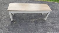 Full front view of a wooden bench with a flat top and sturdy legs.