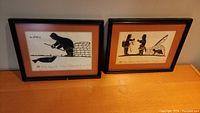 Two framed Inuit silhouette prints side by side on a flat surface