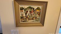 Framed overall view of the oil painting depicting sailboats at dock with buildings and trees in background.