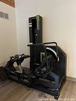 Side angle view of the MedX lumbar strength machine showing the full length and structure with pelvic restraint, seating, and weight stack.