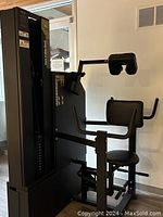 Side view of MedX Core 4-Way Neck machine showing padded neck support, seat, and arm grips with weight stack on the left.