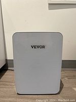 Front view of white Vevor mini fridge with logo on door.