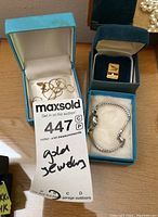 Liberty wristwatch in blue box, postal tie tac, tangled chains in separate box