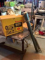 Kodak Brownie 500 projector box with movie screen tube leaning against table