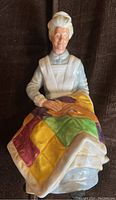 Front view of the Royal Doulton 'Eventide' figurine showing the elderly woman knitting a multicolored quilt.