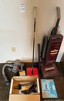 Hoover upright vacuum, Dyson handheld vacuum with hose and attachments, Bissell push cleaner with accessories.