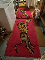 Two matching woven rugs laid out on the floor, showing full design and size.