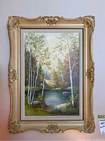 Framed oil painting of a forested river landscape with birch trees, measuring about 31x23 inches framed.