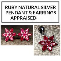Photo showing ruby studded polished silver pendant and earrings in floral design.