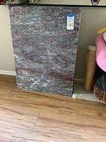 Photo showing the entire marble base of the table resting on a wood floor.