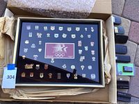 Complete view of the Olympic pin display case with garage door openers placed to the right.