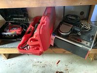 Photo showing Milwaukee Sawzall and Skil handheld jigsaw in red cases, plus Sony videocorder on shelf